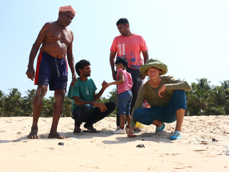 Freiwilliger mit Fischern in Indien am Strand