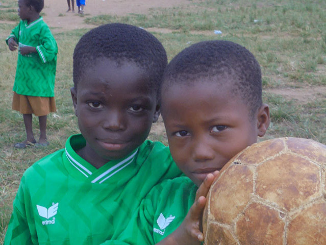 Zwei Kinder und ein Fußball, Nahaufnahme Gesichter