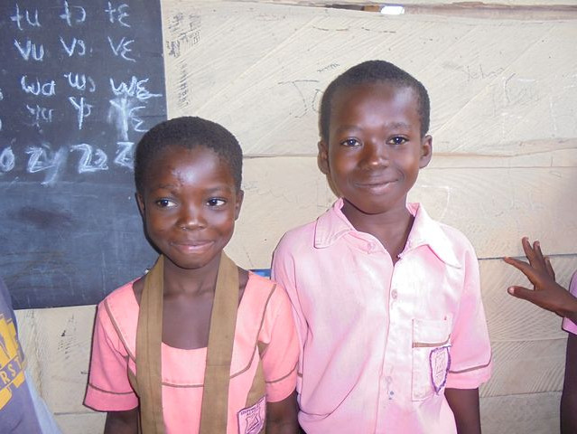 Zwei Kinder lächeln schüchtern ins Bild