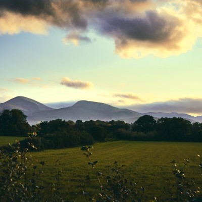 gruene landschaft mit bergen und wolkenhimmel in nordirland