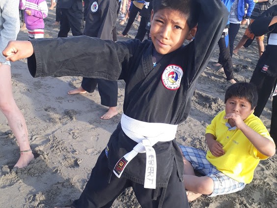 Junge macht Kampfsport am Strand v2