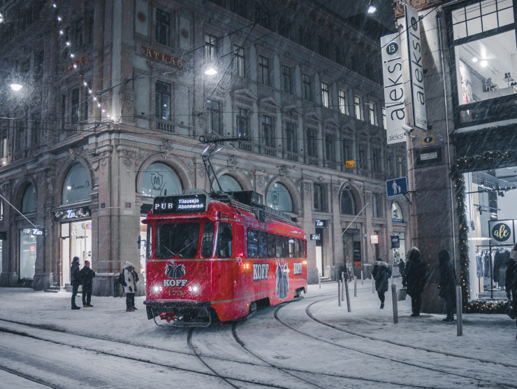 rote Straßenbahn in einer winterlich verschneiten Stadt