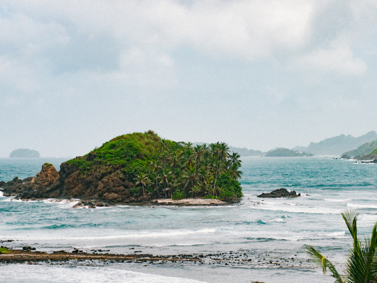 ein bewachsener Fels vor einem Strand in Panama