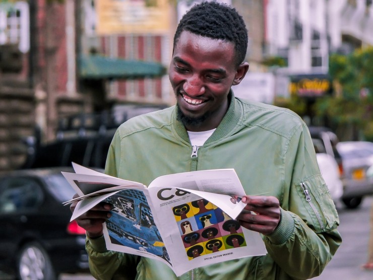 Junger Mann liest Magazin auf der Straße