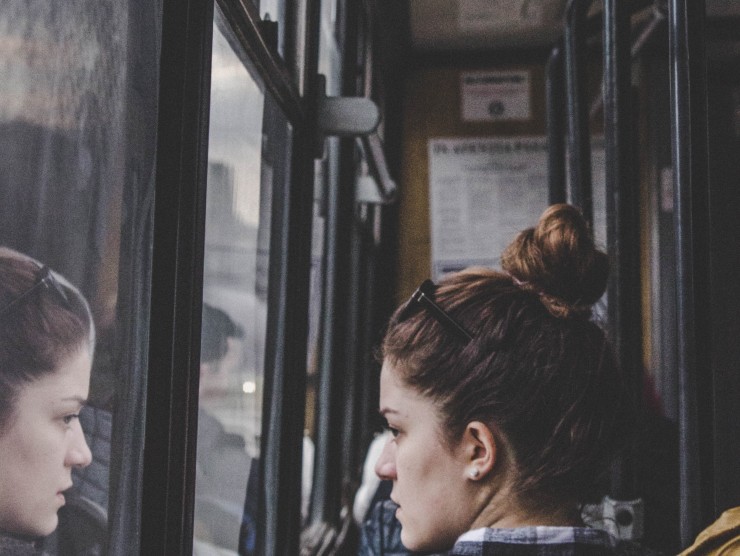 junge Frau blickt aus dem Busfenster