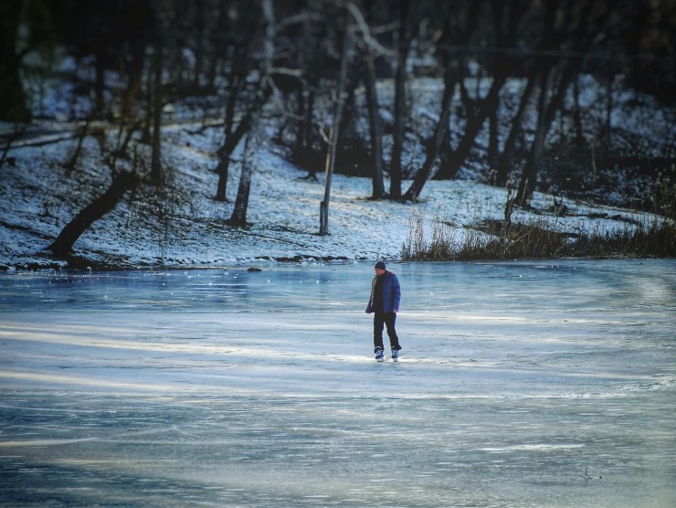 Schlittschuh-fahrende Person auf zugefrorenem See